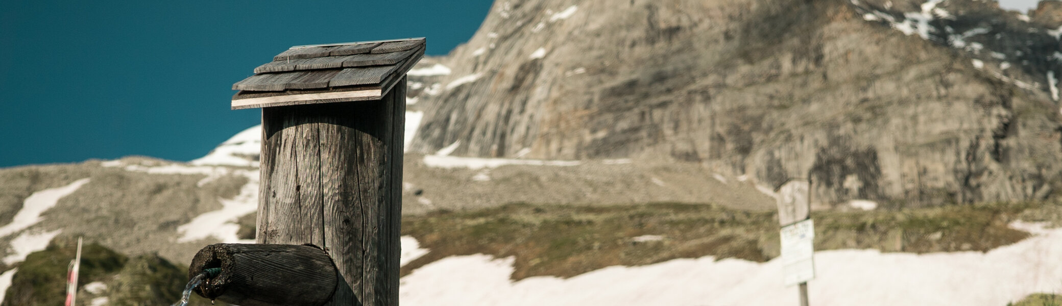 Ein Holz-Brunnen in den Bergen | © DAV/Marcel Dambon